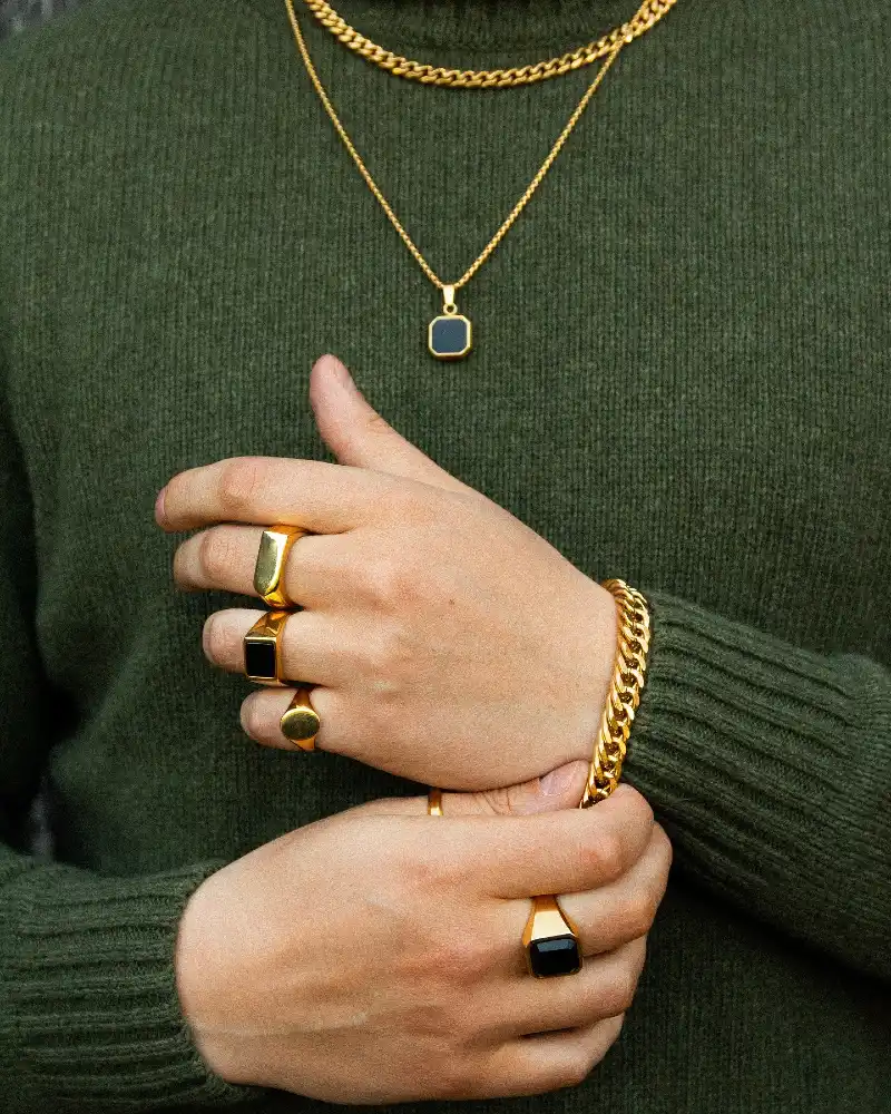 Gold Chains, Rings, and Bracelet with Green Sweater