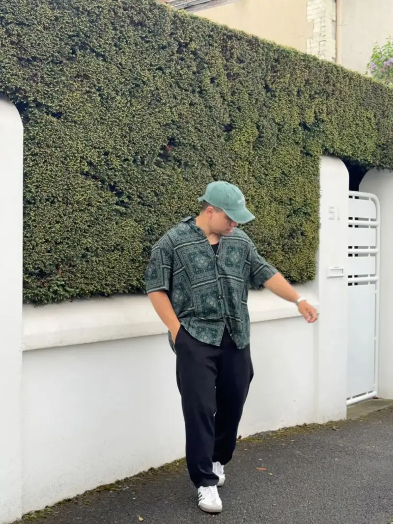 Green Patterned Short-Sleeve Shirt, Black Trousers, and Green Baseball Cap
