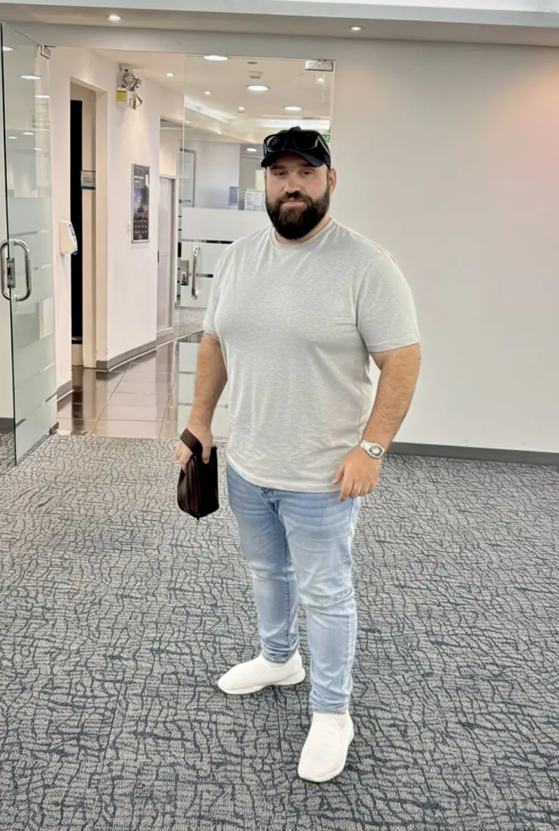 Grey T-Shirt, Light Wash Jeans, White Sneakers, Black Baseball Cap, and Accessories