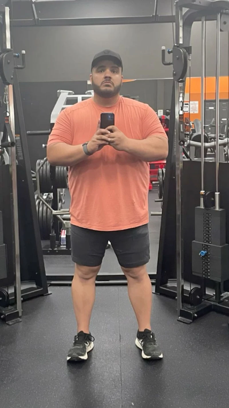 Peach T-Shirt, Dark Grey Athletic Shorts, Black Sneakers, and Black Baseball Cap