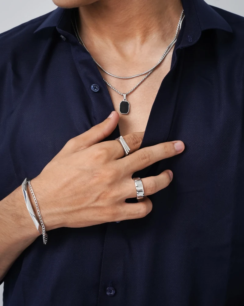 Silver Chains, Rings, and Bracelets with Navy Blue Shirt