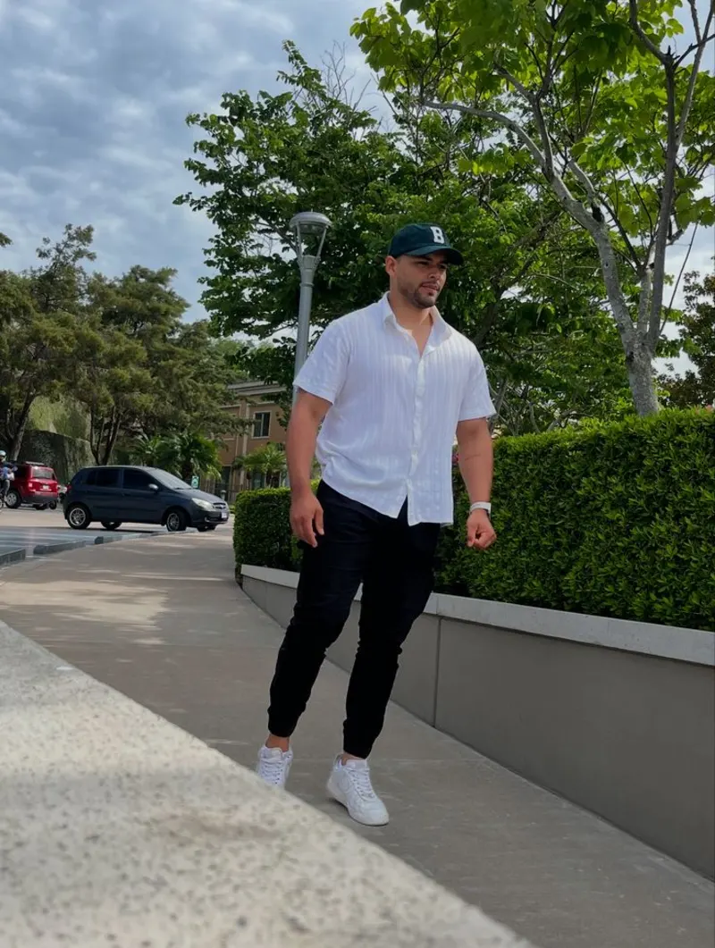 White Textured Button-Down Shirt, Black Joggers, and Dark Green Baseball Cap