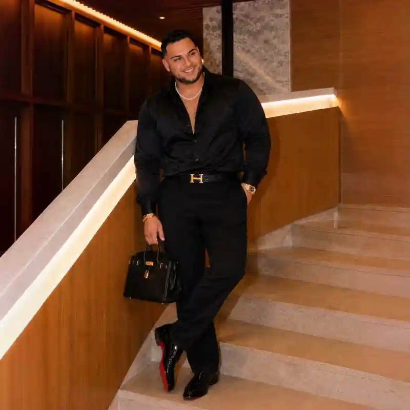 black button-up shirt, black dress trousers, black leather shoes, and accessories
